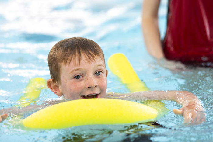 Child swimming with a floating aid