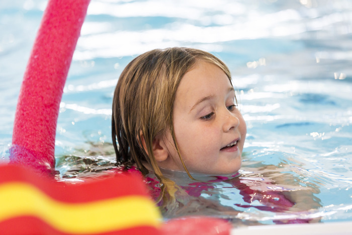 Child swimming with a floating aid